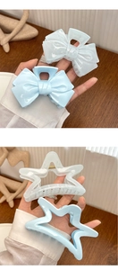 Detailed view of mint blue bow and star hair claws in translucent acrylic material