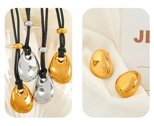 Detailed set of gold and silver pebble pendants on black cords with matching stud earrings