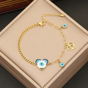 Gold-tone evil eye bracelet featuring heart pendants and nazar charms on a jewelry box