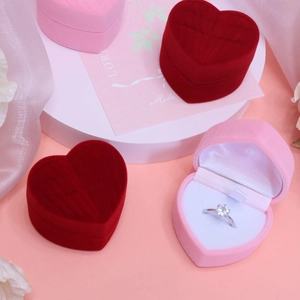 Pink and red heart-shaped velvet ring boxes with white sponge inserts on silk fabric