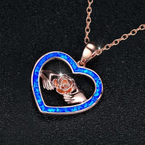 Macro detail of heart-shaped pendant with blue opal border and rose gold finish