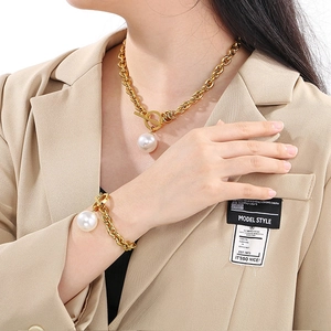 Detail of gold chunky chain necklace and bracelet set with large pearls and OT toggle clasp
