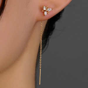 Close-up of gold tassel earring featuring sparkling zircon petals and slender chain