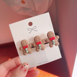 Detailed close-up of cute gingerbread man hair clips with resin finish and card backing