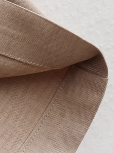 Macro shot of khaki cotton fabric texture showing neat stitching and fine twill weave detail