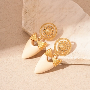 Détail de boucles d'oreilles vintage avec nœuds et zircons sur une base en pierre