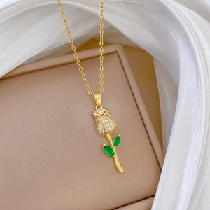 Close-up of a gold rose necklace with crystals inside a luxury beige jewelry box