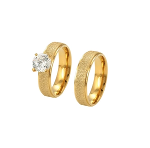 Detailed view of gold frosted titanium steel couple rings with a round zirconia stone