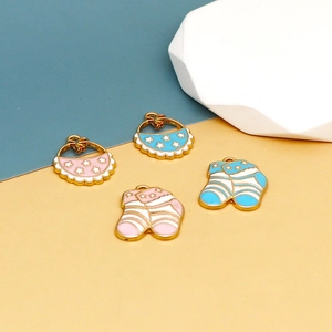 Detail of pink and blue enamel baby bibs and socks pendants with gold metal edges