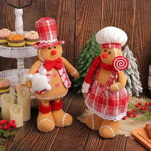 Pair of plush gingerbread man Christmas dolls on a tiered tray with festive decor