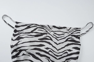 Close-up detail of satin zebra print camisole top featuring thin shoulder straps