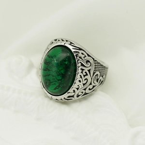 Dettaglio di anello vintage argento con gemma verde ovale e incisioni curate