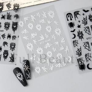 Detail of Halloween nail stickers with black spider webs and bats on manicured nails