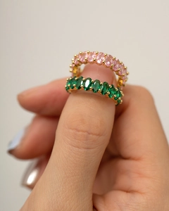 Detail of two gold rings featuring oval-cut pink and green zircon gemstones