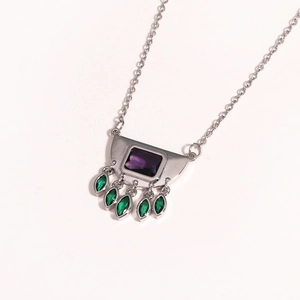 Detail of silver necklace with purple square gem and green marquise stone tassels