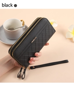 Detail view of black quilted faux leather long wallet with double zippers and wrist strap