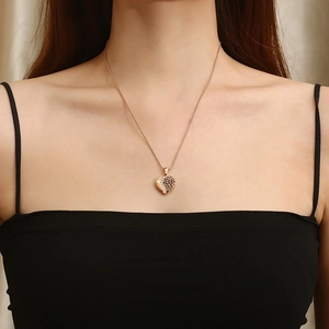 Gros plan du pendentif cœur doré avec motifs ajourés complexes et diamants latéraux