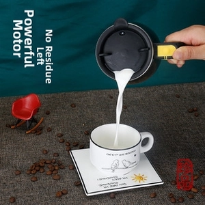 Action shot of milk being poured into a black automatic stirring mug with a yellow button