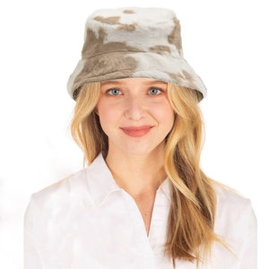 Winter fluffy cow print bucket hat in soft faux fur worn by a model on white background