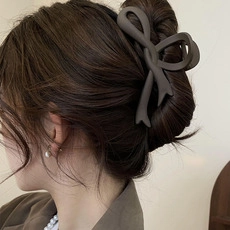Detailed close-up of an elegant matte butterfly hair claw clip on a woman's bun hairstyle