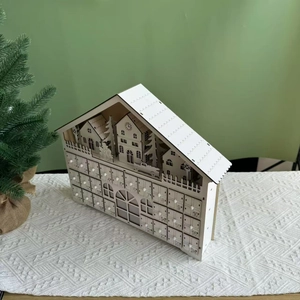 Detail of wooden 24-day advent calendar house with small drawers and numeric engraving