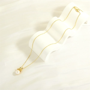 Detail of 18K gold-plated crown pendant with a large freshwater pearl and colored stones