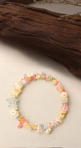 Macro detail of natural colorful crystal bracelet with white shell flower charms