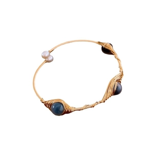 Gold-plated wire-wrapped cuff bracelet featuring white pearls and blue gemstones