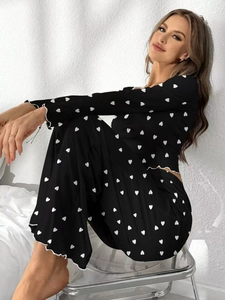 Close-up of black heart print pajama set with delicate white lettuce edge trim details