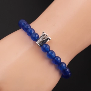 Detail of 8mm faceted blue stone beads and silver crown charm worn by male model