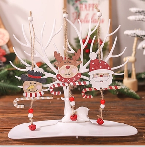 Detail of wooden Christmas ornaments featuring Santa and deer with bells and twine