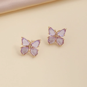 Detailed macro view of small gold butterfly stud earrings with purple zircon wings