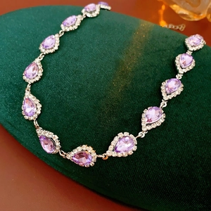 Detail of silver bracelet featuring purple pear-cut gems and sparkling zircon accents