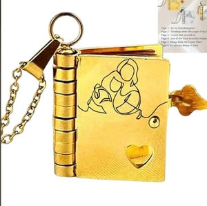 Macro detail of gold titanium steel book necklace featuring engraved pages and heart cutout