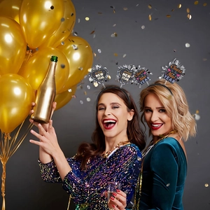 Close-up of Happy New Year party headbands with gold and silver glitter stars on models
