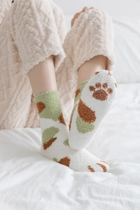 Detail of soft fleece bed socks featuring a brown bear paw print on the sole