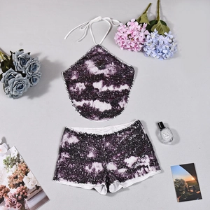 Flachliegendes Set aus lila Pailletten-Neckholder-Top und Shorts mit Batikmuster und Blumen