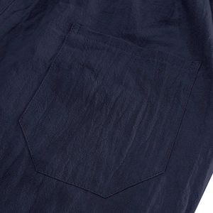 Detail of navy blue linen fabric with a pentagonal patch pocket and double stitching