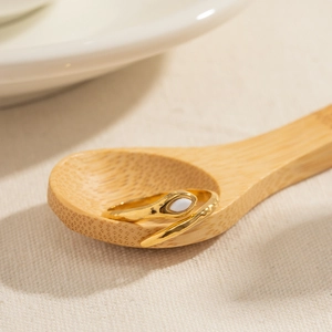 18K gold plated stainless steel snake ring with white marquise stone on wooden spoon