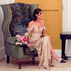 Elegant champagne gold satin off-shoulder evening gown with slit and draped silhouette