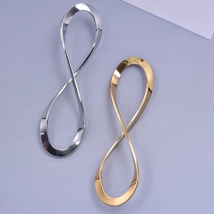 Polished silver and gold infinity pendants in stainless steel on light purple background
