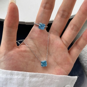 Macro view of blue cushion cut zircon stone necklace and matching silver ring