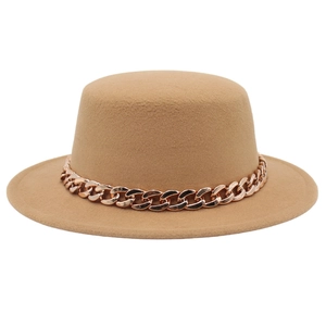 Elegante cappello in feltro cammello con catena in acrilico oro rosa su uno sfondo bianco