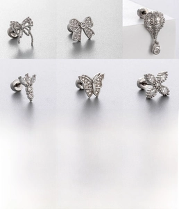 Detailed view of silver bow and butterfly titanium steel studs with zircon inlays