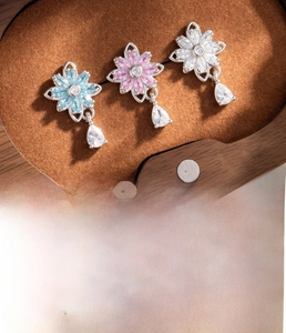 Detailed close-up of floral ear studs with blue pink and white zircon stone pendants