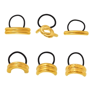 Set of six gold geometric metal hair ties with black elastic bands on white background