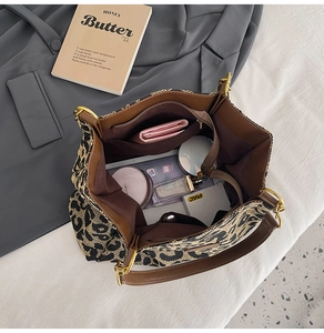 Flat lay of leopard print tote bag interior showing large storage capacity and PU leather straps