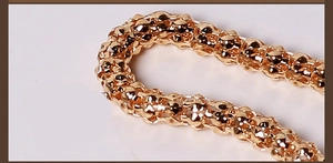 Close-up of golden woven metal waist chain texture on a clean white background