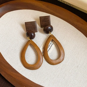 Detailed view of vintage wood earrings with tiger eye stone and 18k gold plating