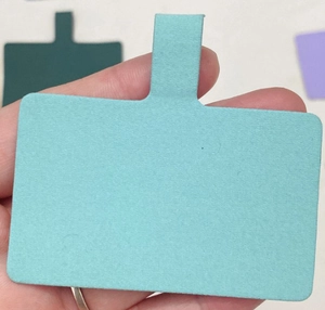 Close-up of a light blue rectangular phone lanyard card patch held in hand for scale
